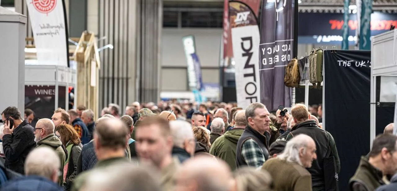 Crowds walk through a busy show hall at the Great British Shooting Show at the NEC Birmingham, with exhibitors and shooting brands on display